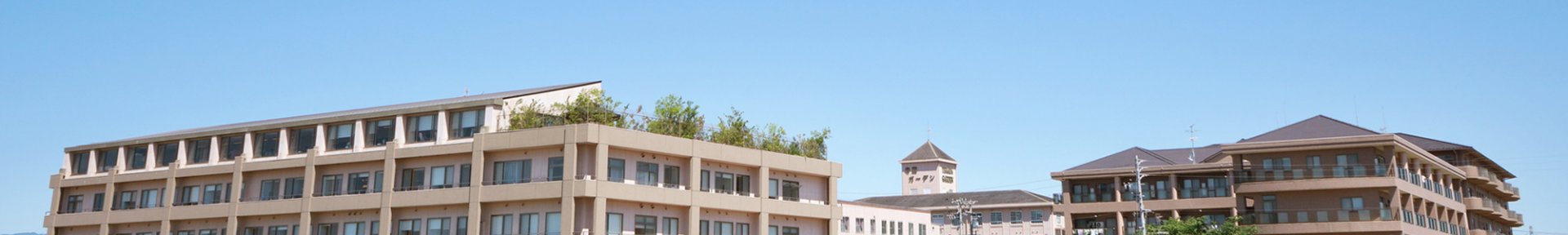 複数棟の介護施設建物群。晴天下での外観撮影で、施設全体の配置が確認できます。